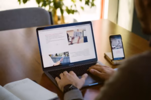 صاحب کسبوکار در حال بررسی وبسایت خدمات خود روی لپتاپ